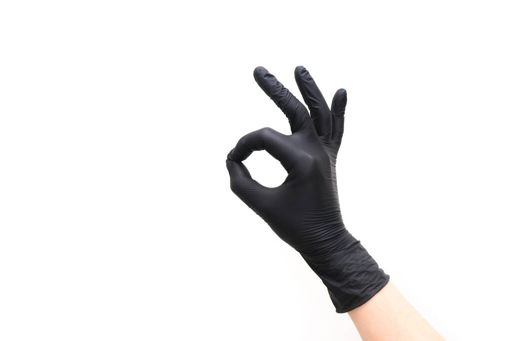 ręka w czarnej rękawicy pokazuje ok gest na białym odizolowanym tle - Zdjęcie, obraz