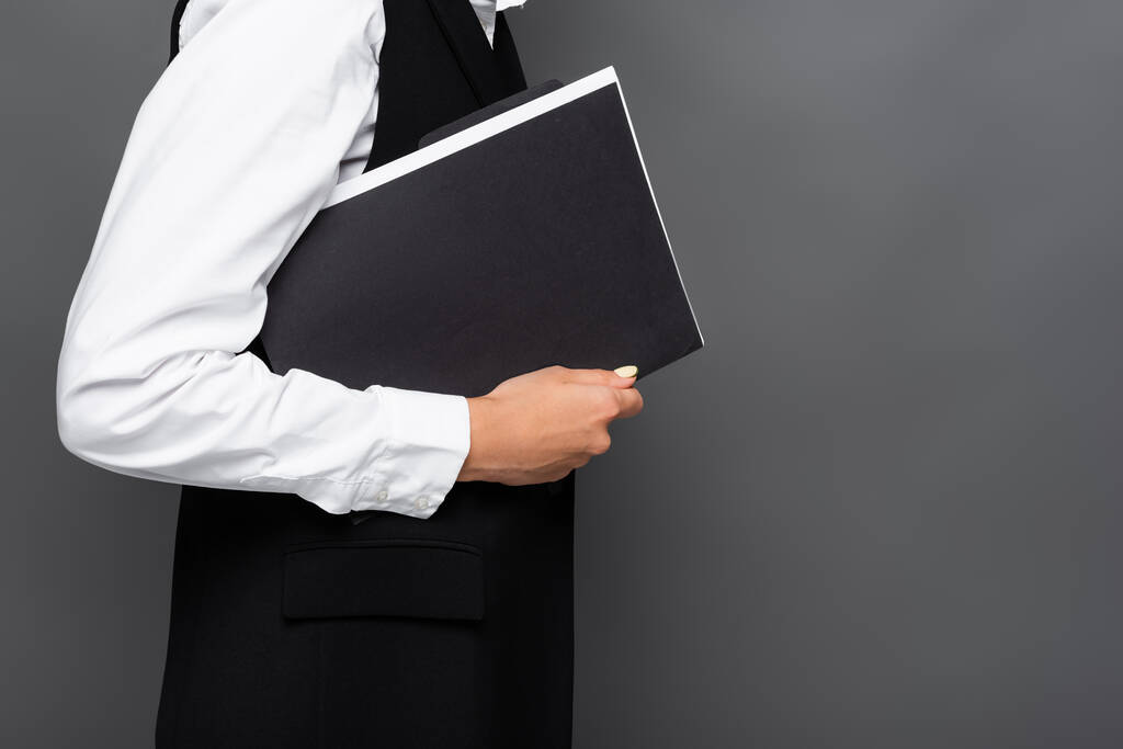 Cropped view of businesswoman holding paper folder isolated on grey  - Photo, Image