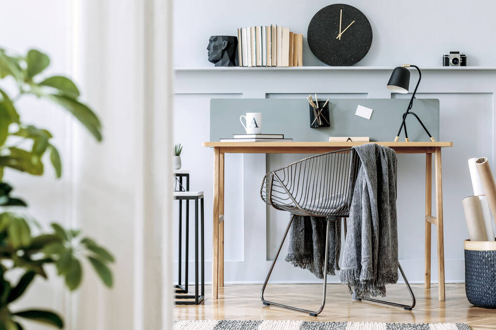 Skandináv otthoni iroda belső tér fa íróasztallal, design szék, fa panelezés polccal, növény, asztali lámpa, szőnyeg, irodai kellékek és elegáns tartozékok a modern otthoni dekoráció. - Fotó, kép