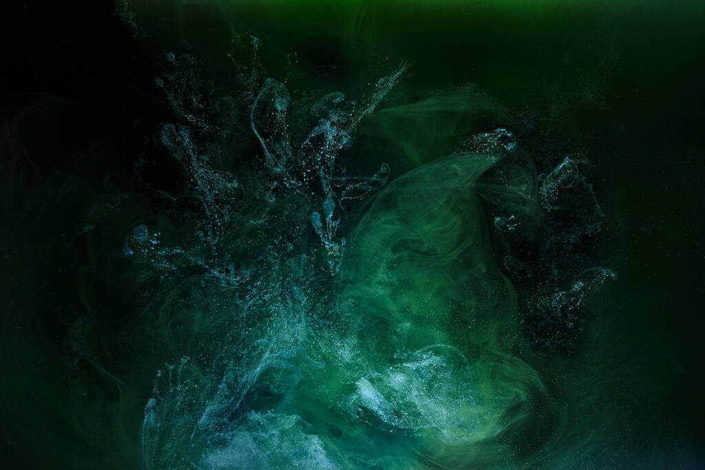 Fumée verte sur fond d'encre noire, brouillard coloré, mer abstraite tourbillonnante émeraude, pigment de peinture acrylique sous l'eau - Photo, image