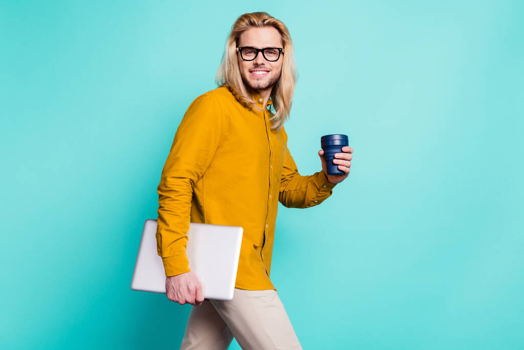 Profilo foto laterale del giovane freelance felice sorriso positivo andare a piedi laptop bere caffè isolato su sfondo di colore turchese. - Foto, immagini