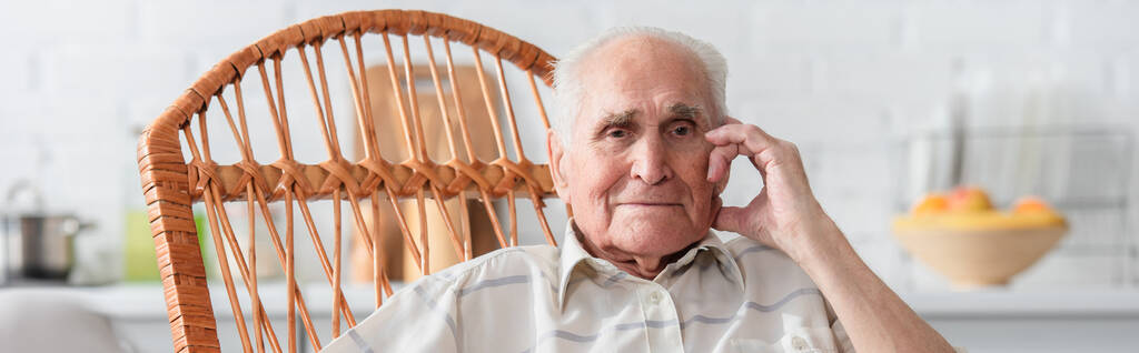 Hombre mayor mirando a la cámara en mecedora en el hogar de ancianos, pancarta  - Foto, imagen