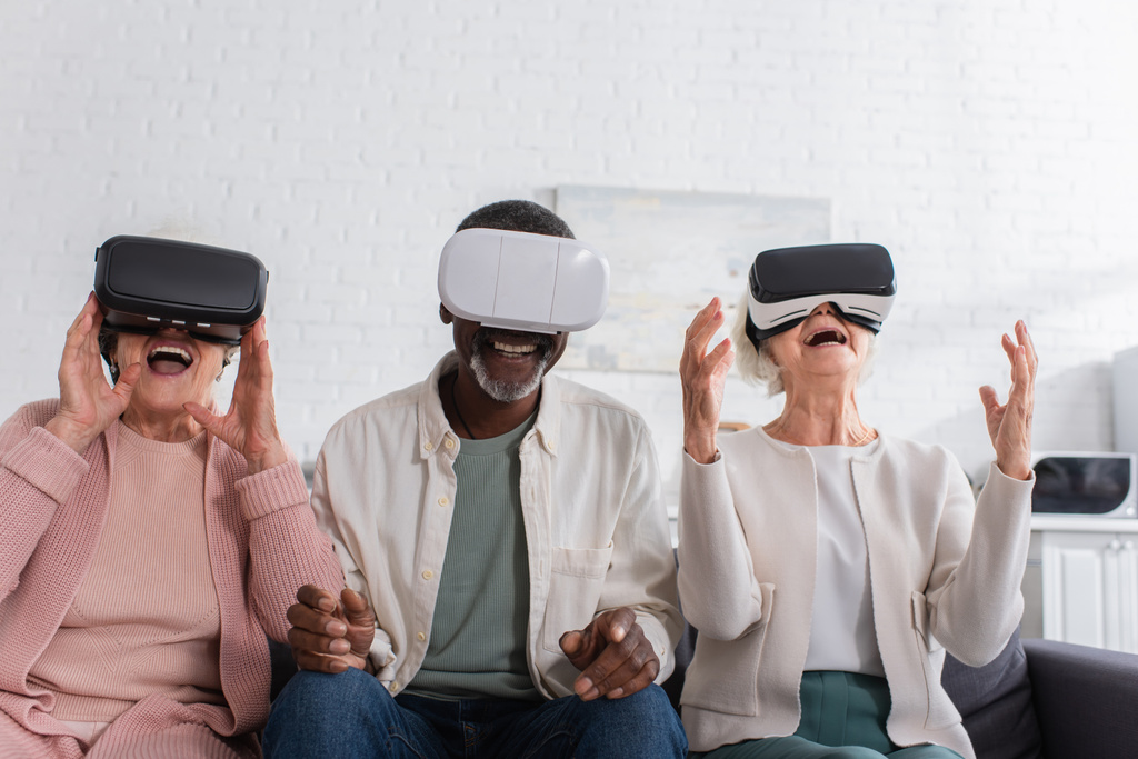 Cheerful interracial pensioners using vr headsets in nursing home  - Photo, Image