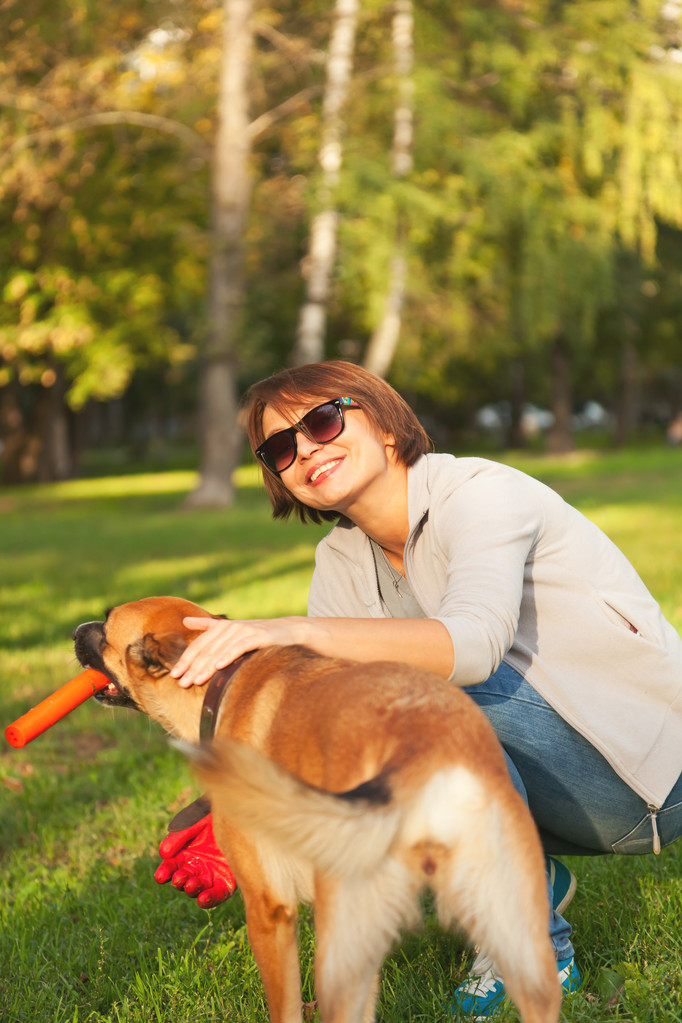 Jovem mulher brincando com cão ao ar livre no parque. - Foto, Imagem