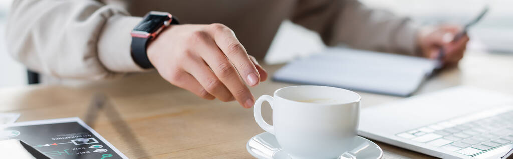 İş adamının laptopun ve kağıdın yanında kahve fincanı götürdüğü kesikli manzara, afiş.  - Fotoğraf, Görsel