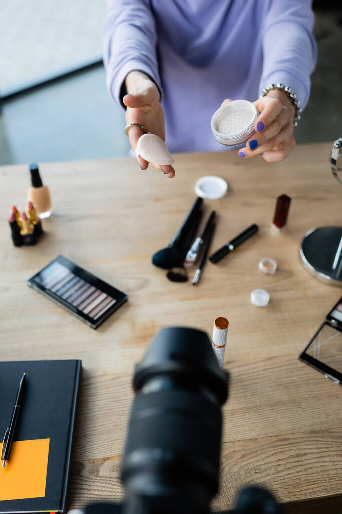 Transseksüel kişinin dijital kamera ve dekoratif kozmetik ürünlerinin yanında yüz pudrası taşıdığı görüntüler.  - Fotoğraf, Görsel
