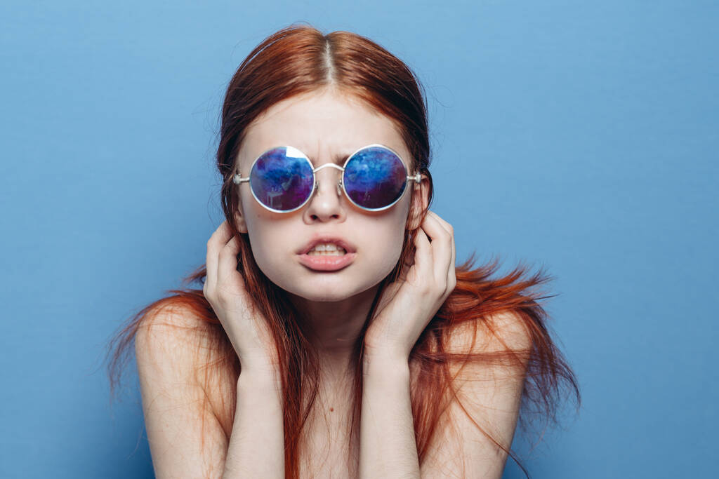 mujer atractiva con hombros desnudos gafas de moda fondo azul - Foto, Imagen