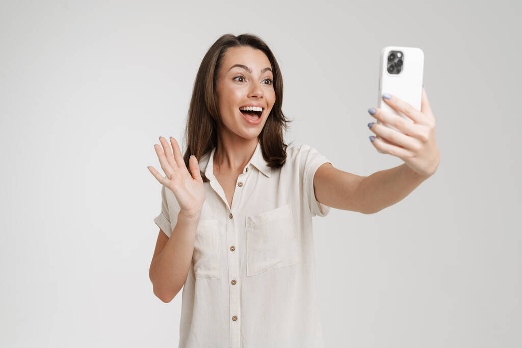 Mladá Evropanka fotit selfie na mobilním telefonu izolované přes bílé pozadí - Fotografie, Obrázek