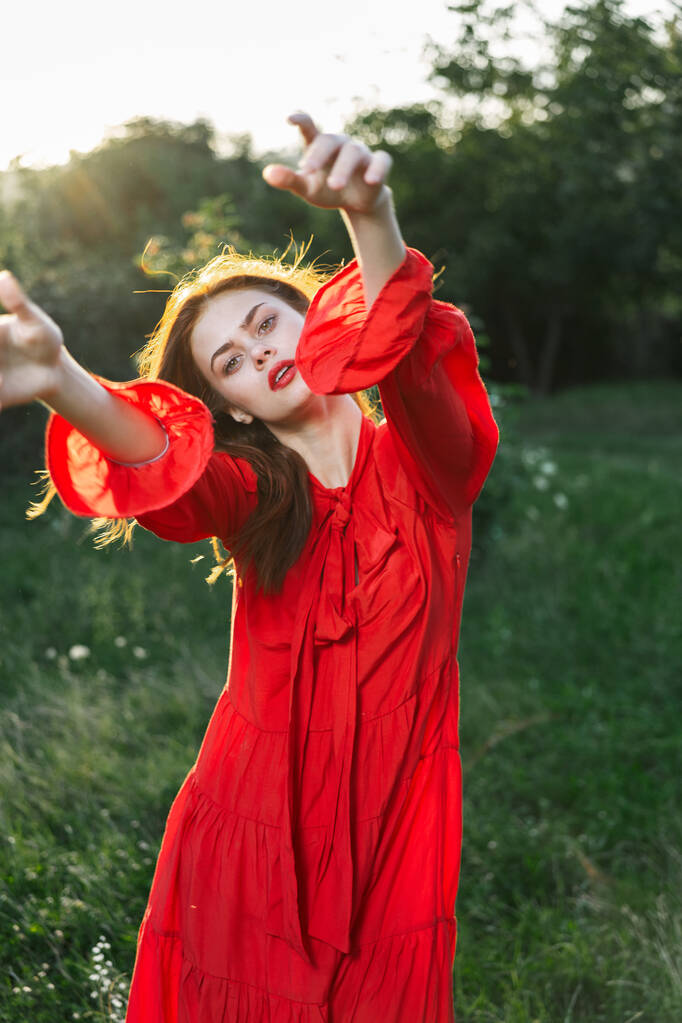 atractiva mujer en vestido rojo al aire libre en campo de libertad - Foto, imagen