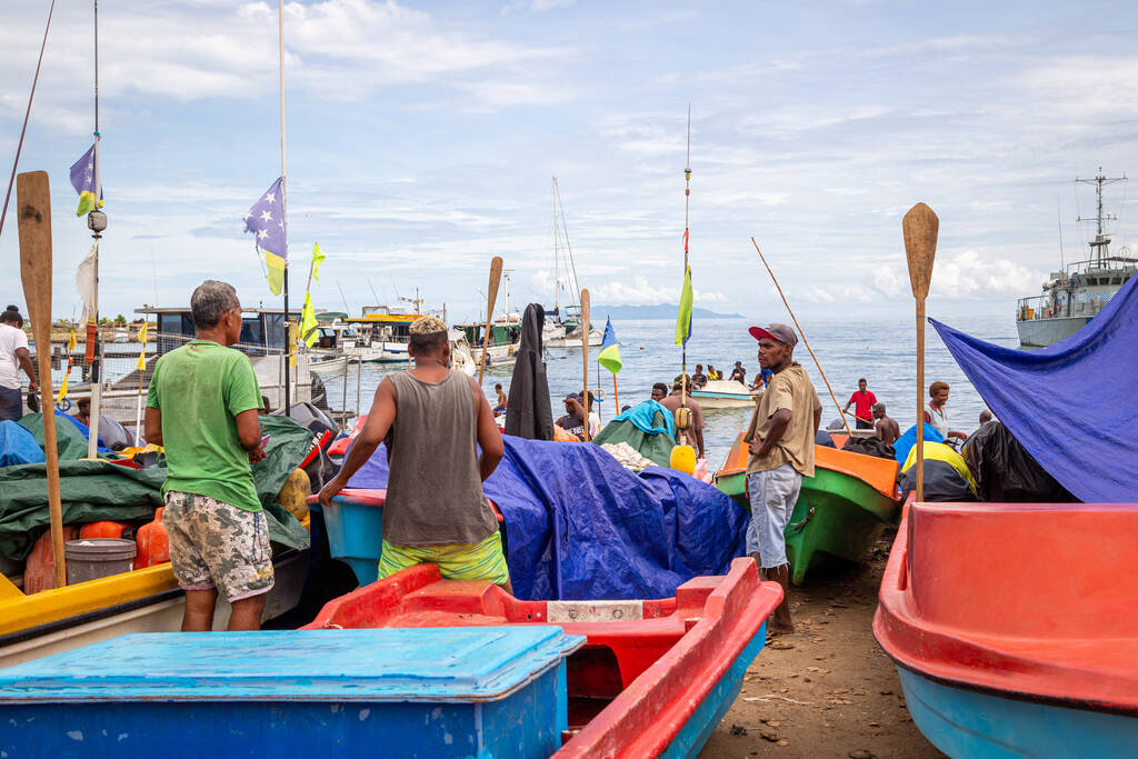 HONIARA, SALOMON ISLANDS - 10. Nov 2016: Menschen, die zwischen Booten fräsen, stehen am Strand des Point Cruz Yatch Club in Honiara, der Hauptstadt der Salomonen. - Foto, Bild