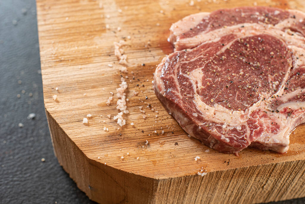 Carne fresca cruda en una tabla de cortar de madera - Foto, imagen