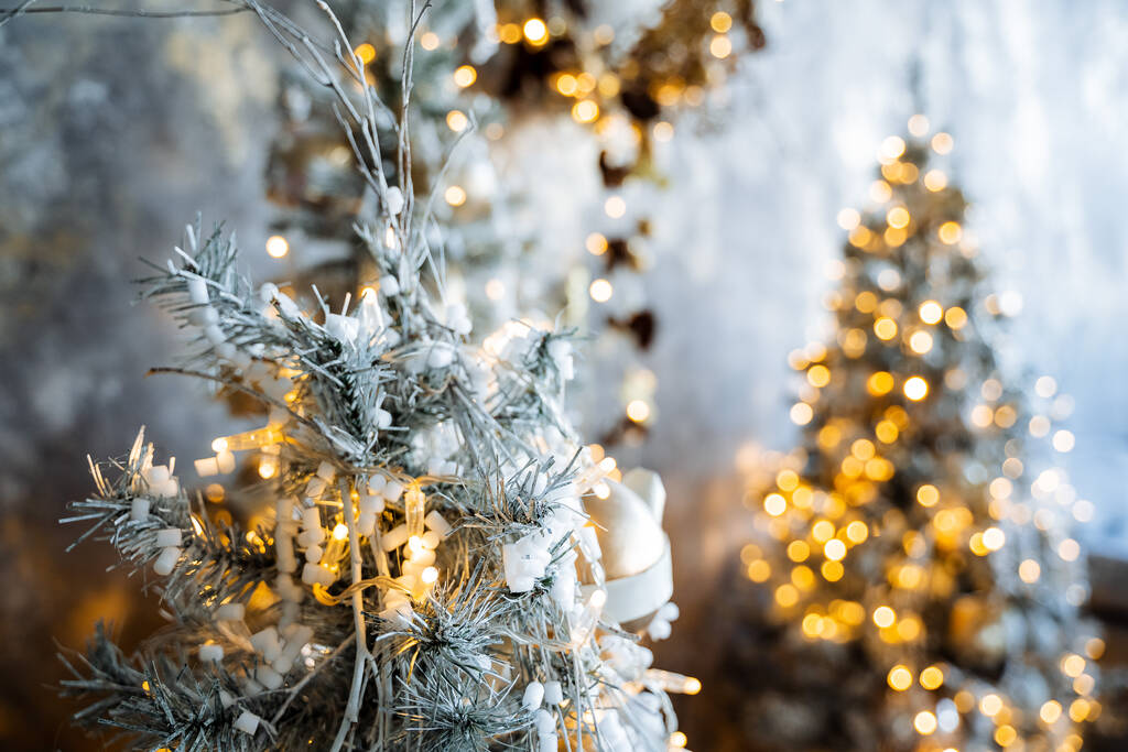 Um tiro de perto de uma árvore de Natal artificial na neve. Guirlandas, ouropel, bolas de Natal. Natal e Ano Novo humor. Brilho e brilho da grinalda. - Foto, Imagem