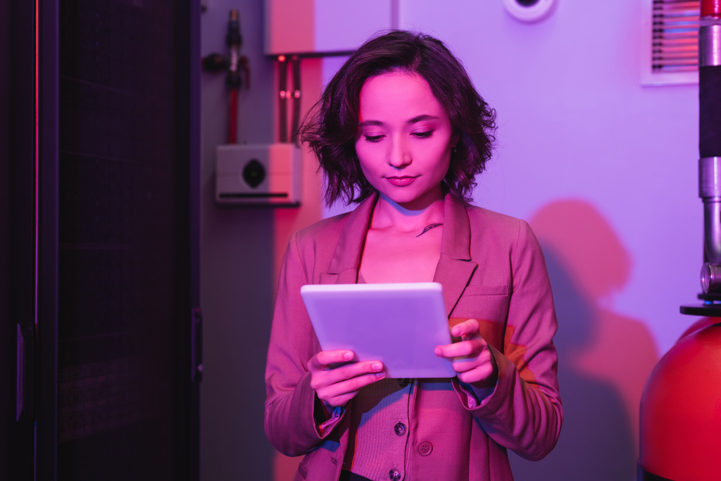 giovane donna che utilizza tablet digitale mentre lavora nel data center - Foto, immagini