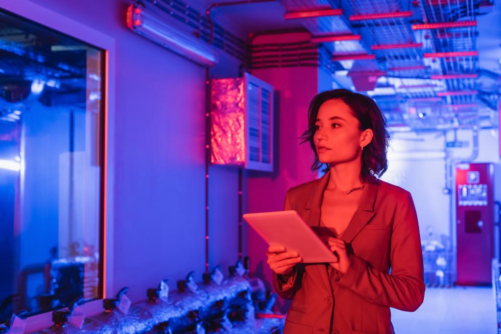 insinööri digitaalinen tabletti seisoo teknisten laitteiden huoneessa datakeskuksen neon valossa - Valokuva, kuva