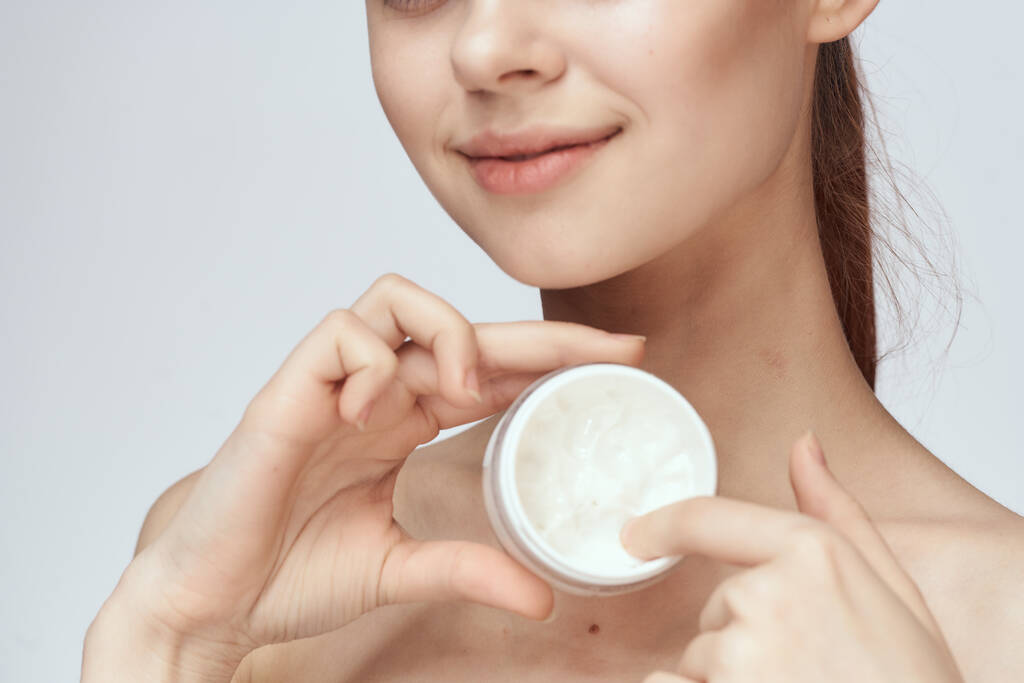 vrouw met pot crème make-up gezicht huidverzorging close-up - Foto, afbeelding