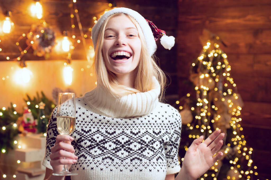 Nő hangulatos kötött pulóver élvezze a karácsonyi hangulatot otthon. Lány téli ruhák Mikulás kalap ünnepelni karácsony és boldog új évet. - Fotó, kép