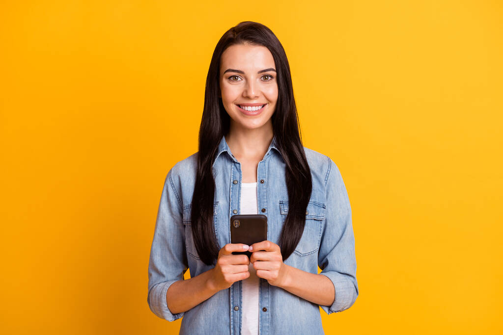 Портрет красивої оптимістичної брюнетки типу леді телефон носити синю сорочку ізольовано на яскраво-жовтому тлі
 - Фото, зображення