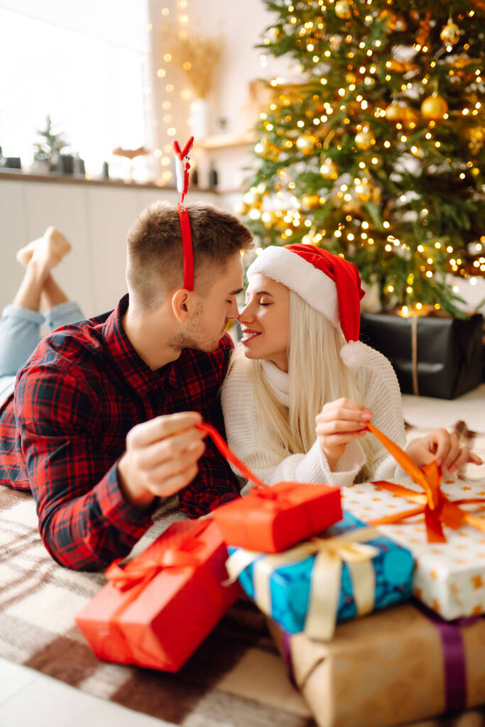 Milující šťastný mladý pár užívající si společně čas u vánočního stromečku. Romantický den. Zimní dovolená. - Fotografie, Obrázek