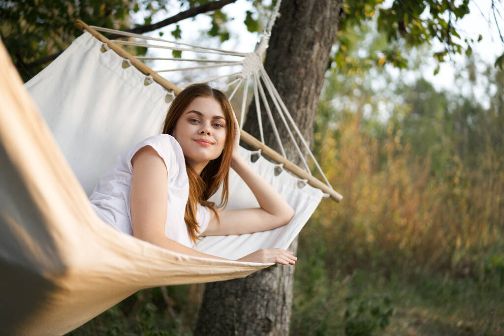 vrolijk vrouw ligt in een hangmat buiten natuur vakantie zomer - Foto, afbeelding