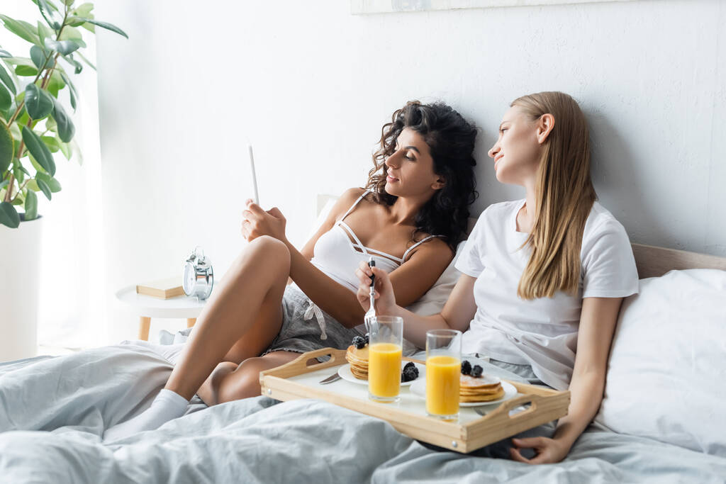 lesbian women looking at pregnancy test near tray with breakfast  - Photo, Image