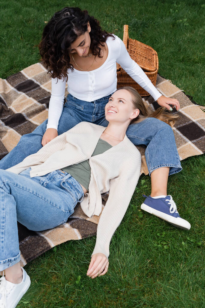 happy lesbian couple lying on plaid blanket during picnic  - Photo, Image