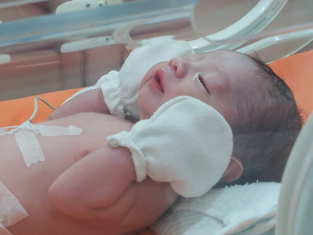Ασιατικό νεογέννητο μωρό χαριτωμένο κοιμάται στο νοσοκομείο. Μικρό αθώο νεογέννητο παιδί στην πρώτη μέρα της ζωής του. έννοια της οικογένειας. - Φωτογραφία, εικόνα