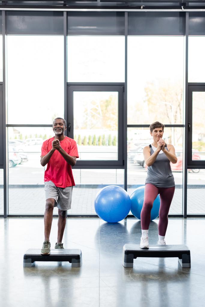 Sénior interracial pessoas treinando em passos aeróbicos no ginásio  - Foto, Imagem