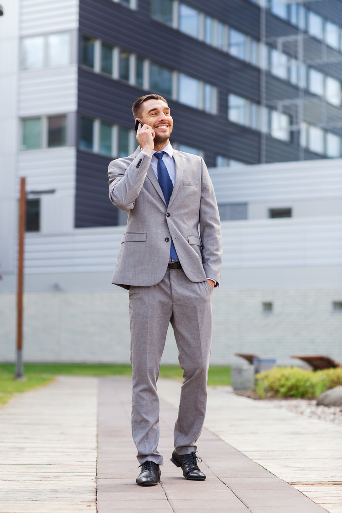 smiling businessman with smartphone outdoors - Photo, Image