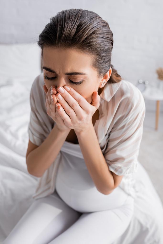 young pregnant woman feeling nausea and covering mouth  - Photo, Image