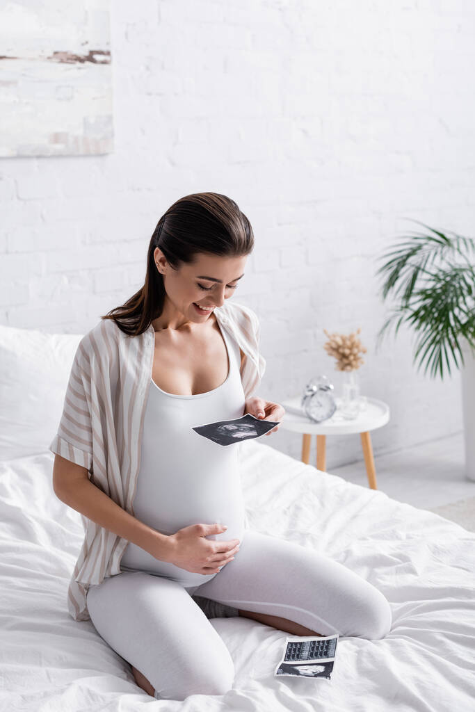 happy pregnant woman holding ultrasound scan  - Photo, Image