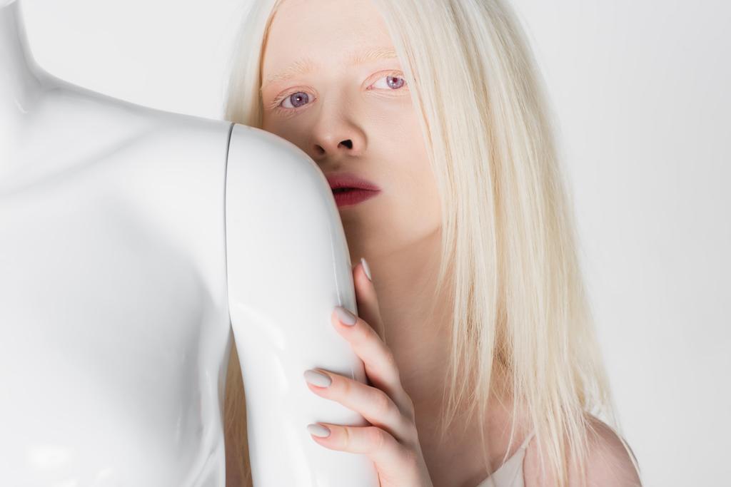 Jolie mannequin blonde toucher mannequin et regarder la caméra isolée sur blanc  - Photo, image