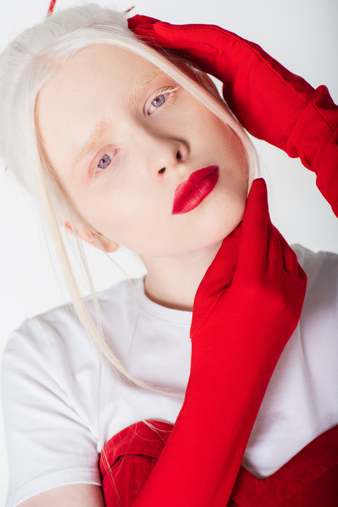 Kırmızı eldivenli albino ve sarışın model beyaz üzerine izole edilmiş poz veriyorlar. - Fotoğraf, Görsel