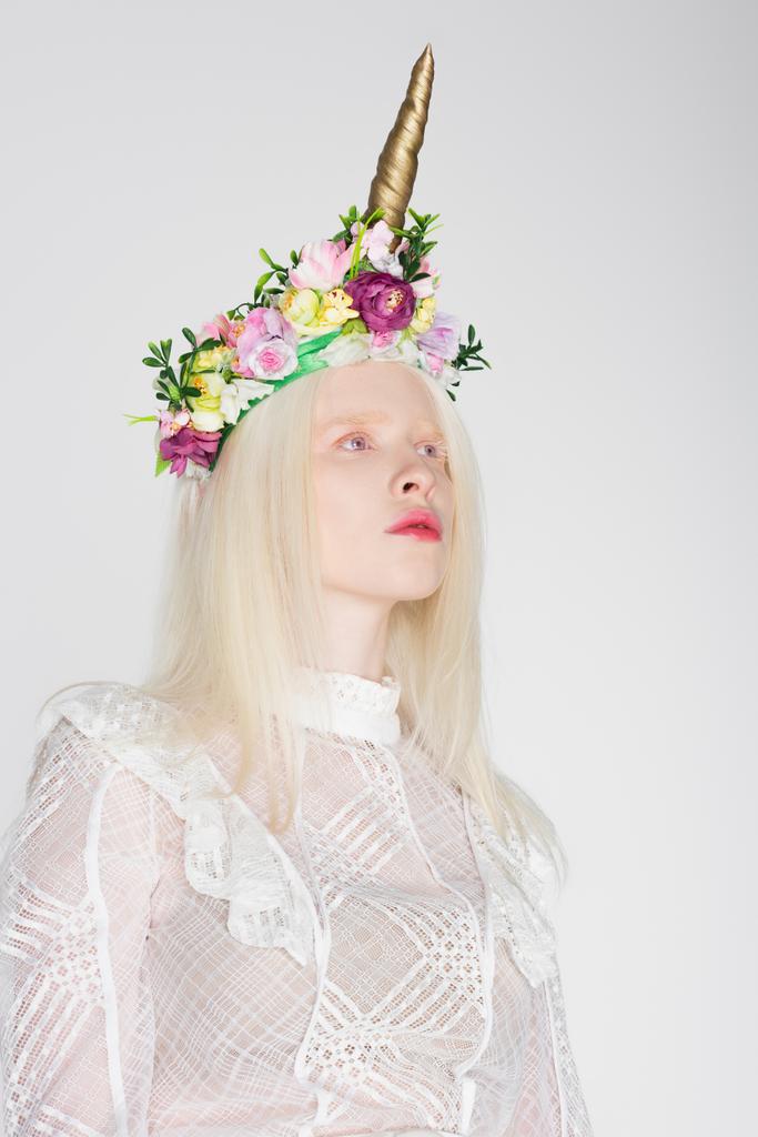 Modèle Albino en chemisier et couronne florale regardant loin isolé sur blanc - Photo, image