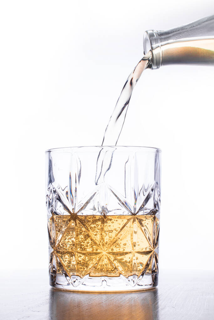 pouring whisky into glass on white background - Fotografie, Obrázek