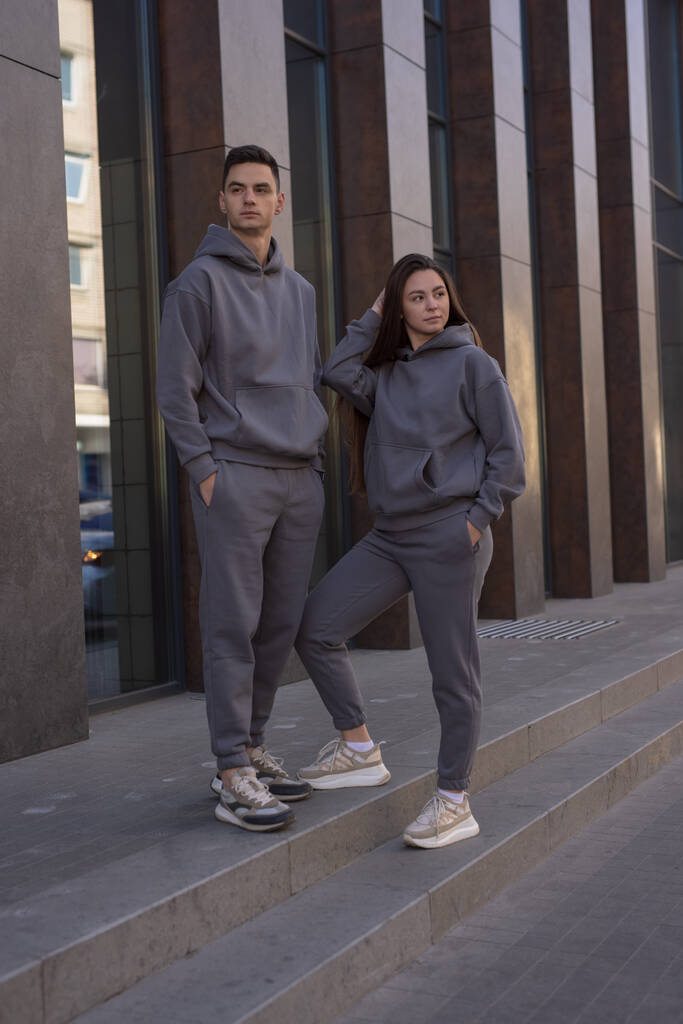 Paar poseren in de stad dragen grijze hoodie - Foto, afbeelding