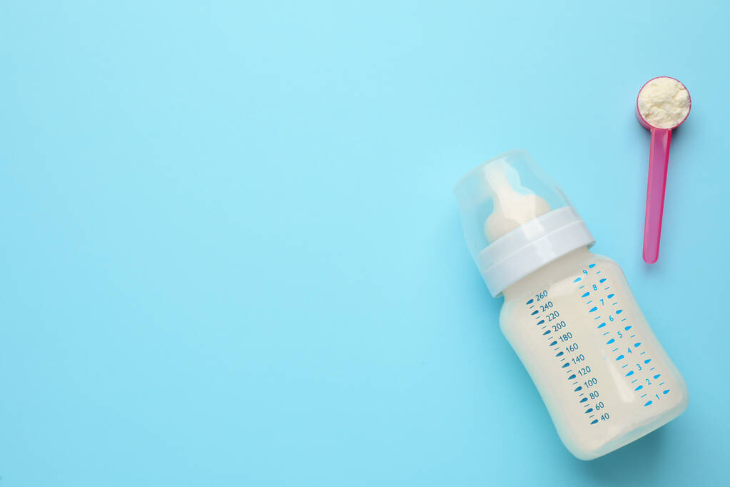 Lahvička s počáteční kojeneckou výživou a práškem na světle modrém pozadí ležela. Mezera pro text - Fotografie, Obrázek