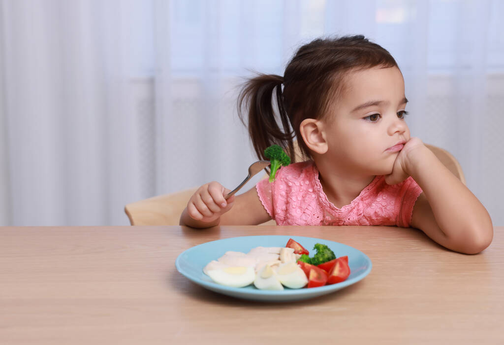 Χαριτωμένο κοριτσάκι αρνείται να φάει το πρωινό της στο σπίτι, χώρος για κείμενο - Φωτογραφία, εικόνα