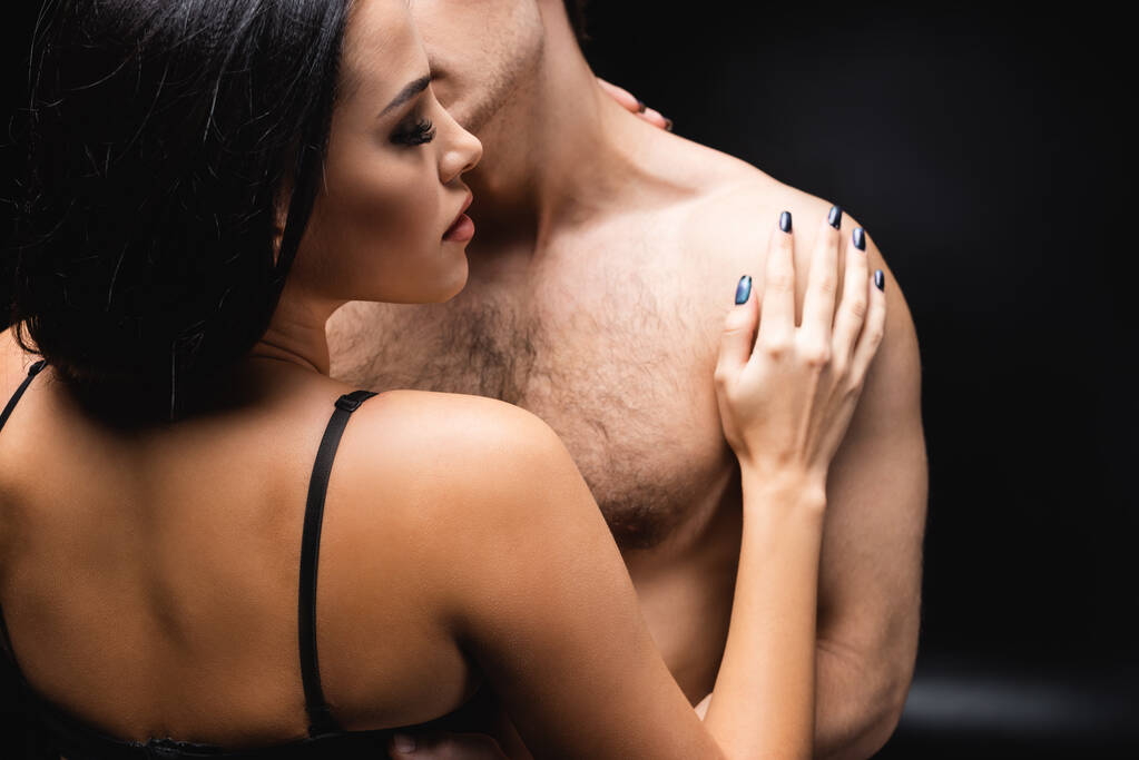 brunette woman in underwear hugging shirtless boyfriend on black - Photo, Image