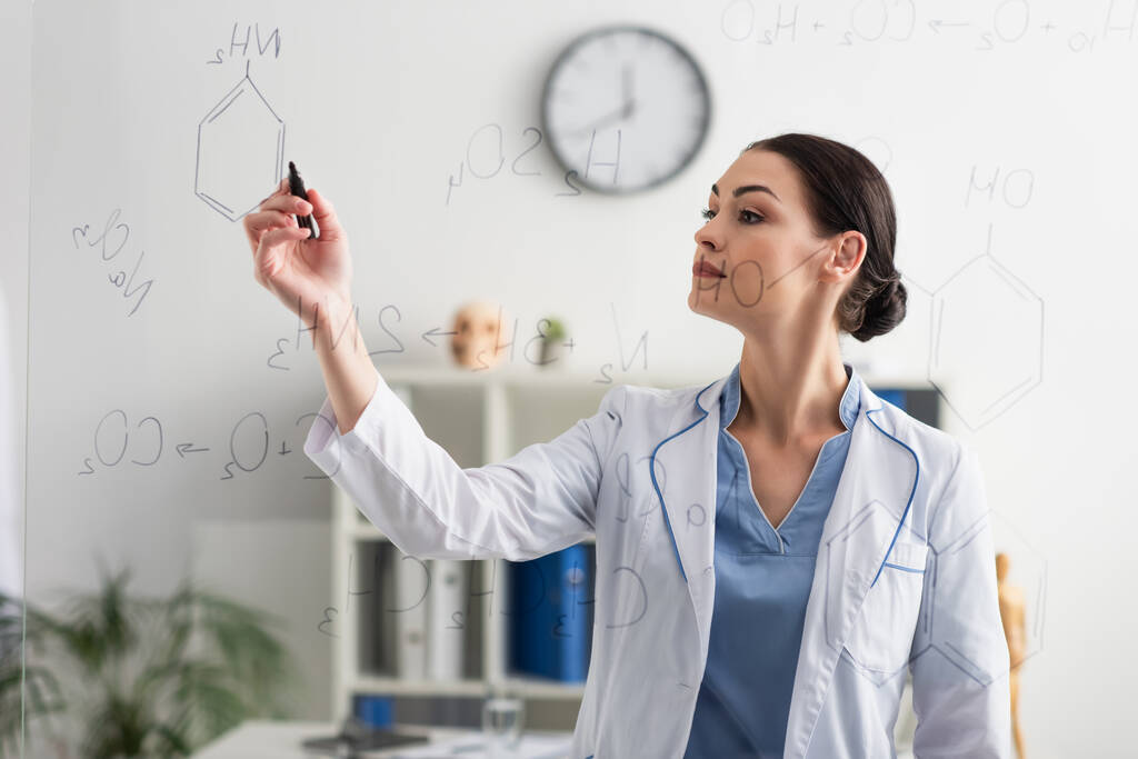 brunetka naukowiec pisanie na szklanej tablicy w klinice - Zdjęcie, obraz