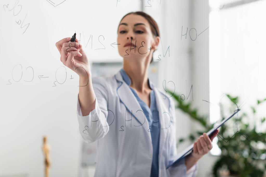 medico offuscata con pennarello e appunti scrittura formule chimiche su tavola di vetro - Foto, immagini