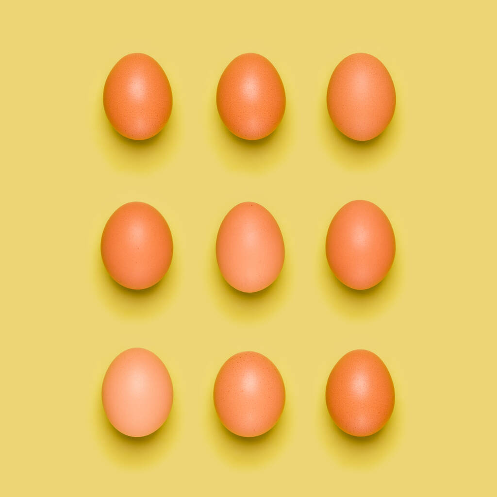 Eier-Muster auf gelbem Hintergrund. Osterkonzept. flache Lage, Draufsicht. Lebensmittel-Hintergrund. - Foto, Bild