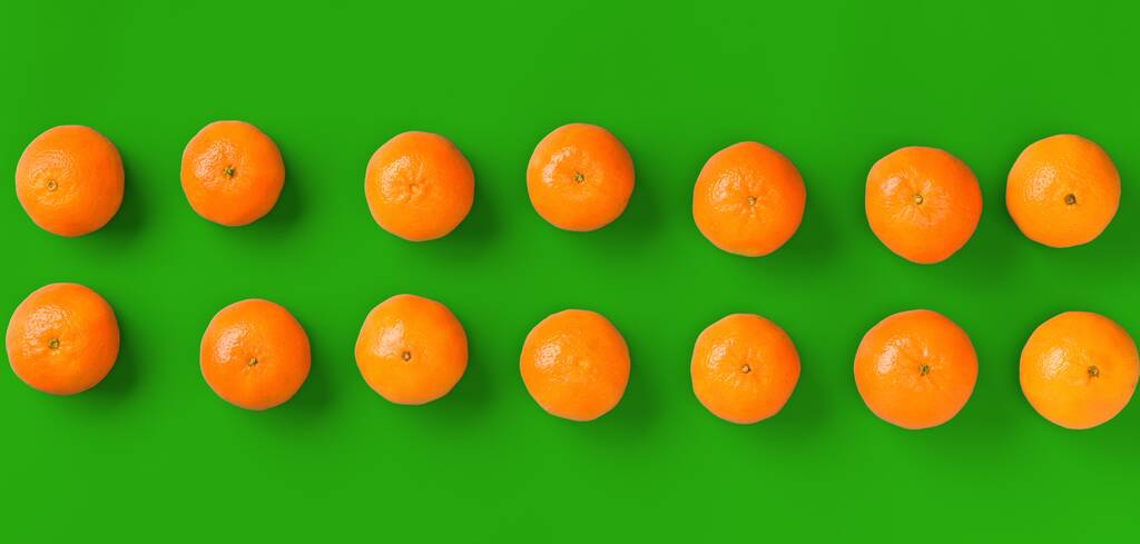 緑の背景に新鮮なオレンジ色のみかんやマンダリンのフルーツパターン。フラットレイ、トップビュー。ポップアートデザイン、クリエイティブな夏のコンセプト。最小限のスタイルで柑橘類. - 写真・画像