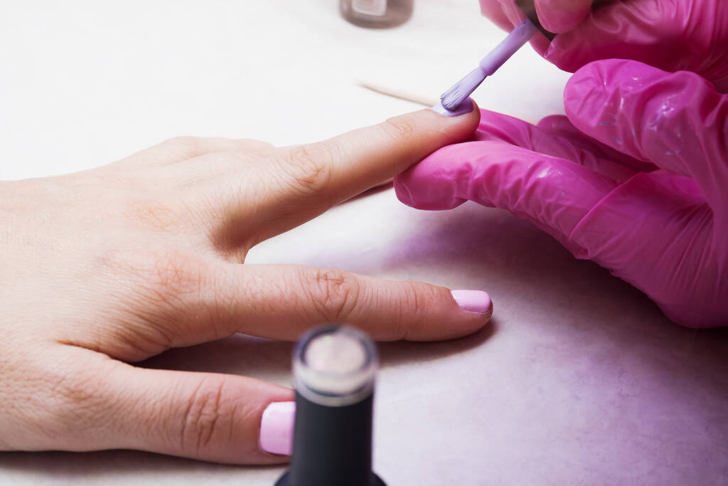 La manicure copre le unghie con vernice. L'idea della cura delle unghie. - Foto, immagini
