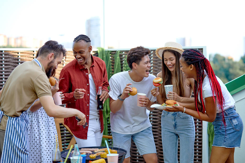 Nemzetközi diákok hamburgert esznek és limonádét isznak a kerti partin - Fotó, kép