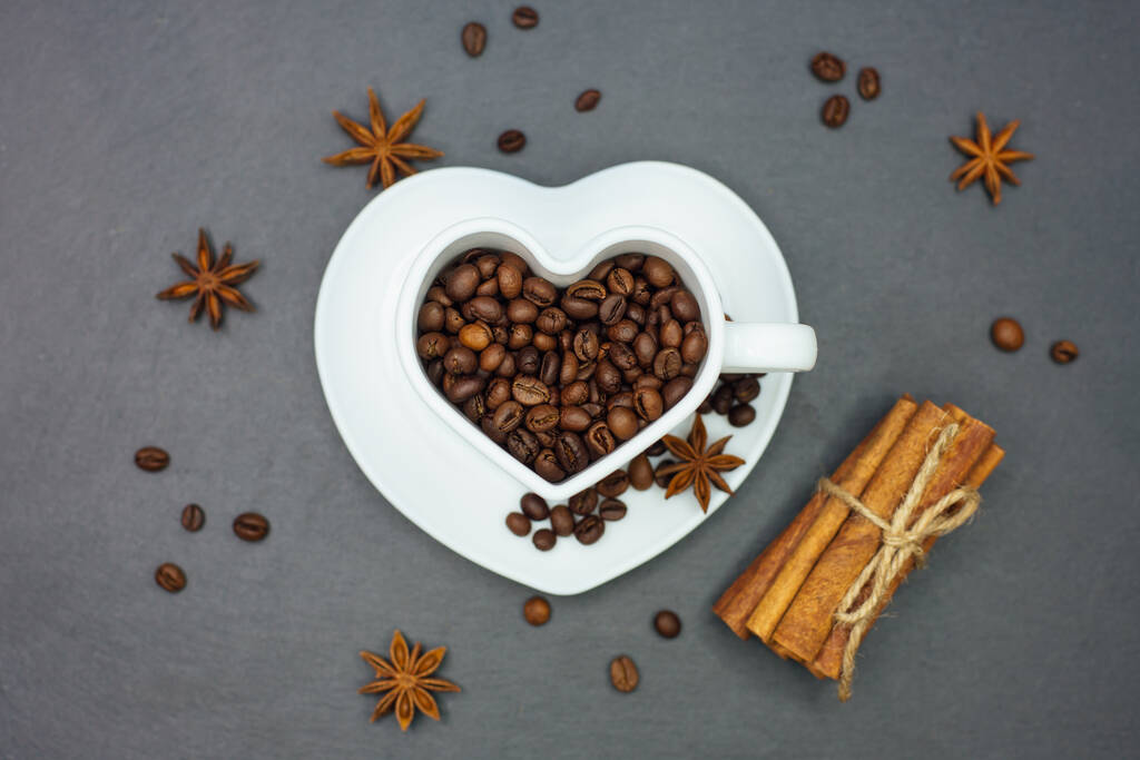 Запеченные кофейные зерна в чашке формы сердца. - Фото, изображение