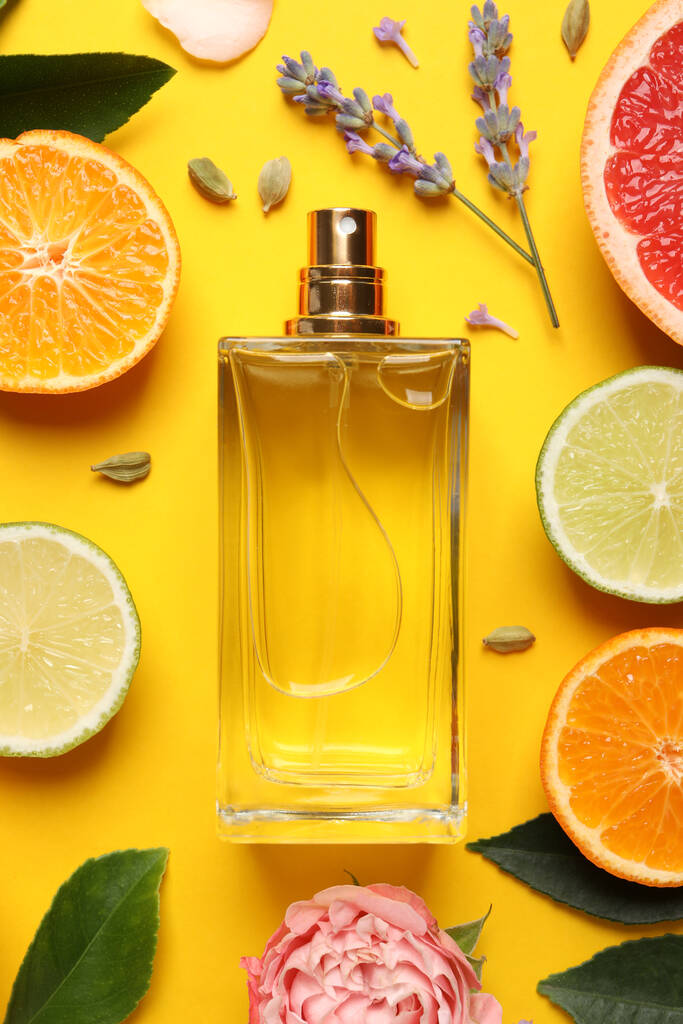Flache Lagekomposition mit einer Flasche Parfüm und frischen Zitrusfrüchten auf gelbem Hintergrund - Foto, Bild