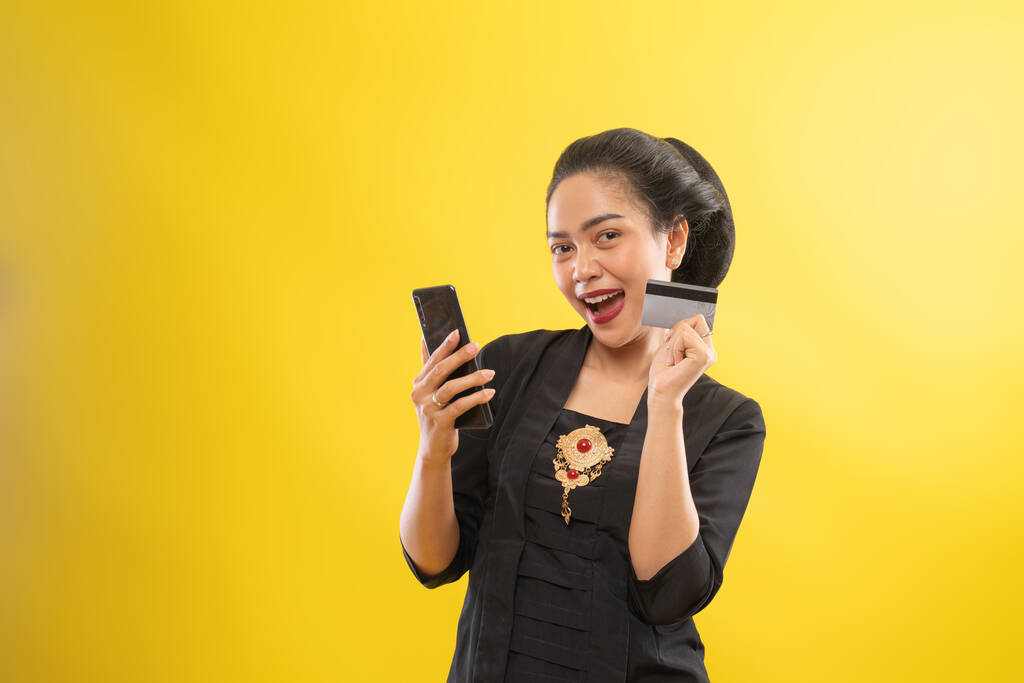 szczęśliwy Azji kobieta z kebaya za pomocą telefon zakupy z karty kredytowej - Zdjęcie, obraz