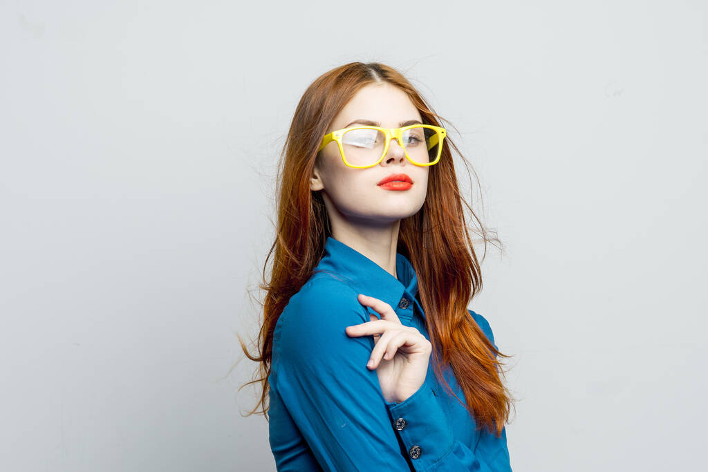 donna in camicia blu occhiali gialli posa moda - Foto, immagini
