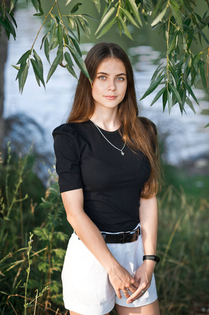 Ein Mädchen im schwarzen T-Shirt und mit einer Tasche in der Weidengasse. - Foto, Bild