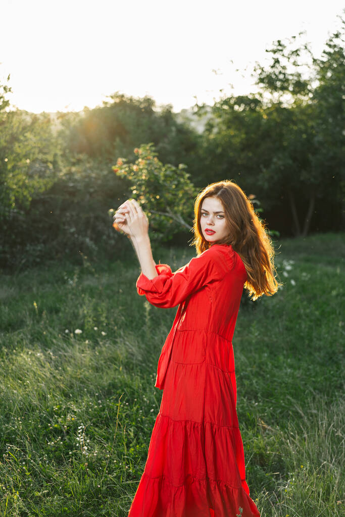 atrakcyjna kobieta w czerwonej sukience na świeżym powietrzu w dziedzinie wolności - Zdjęcie, obraz